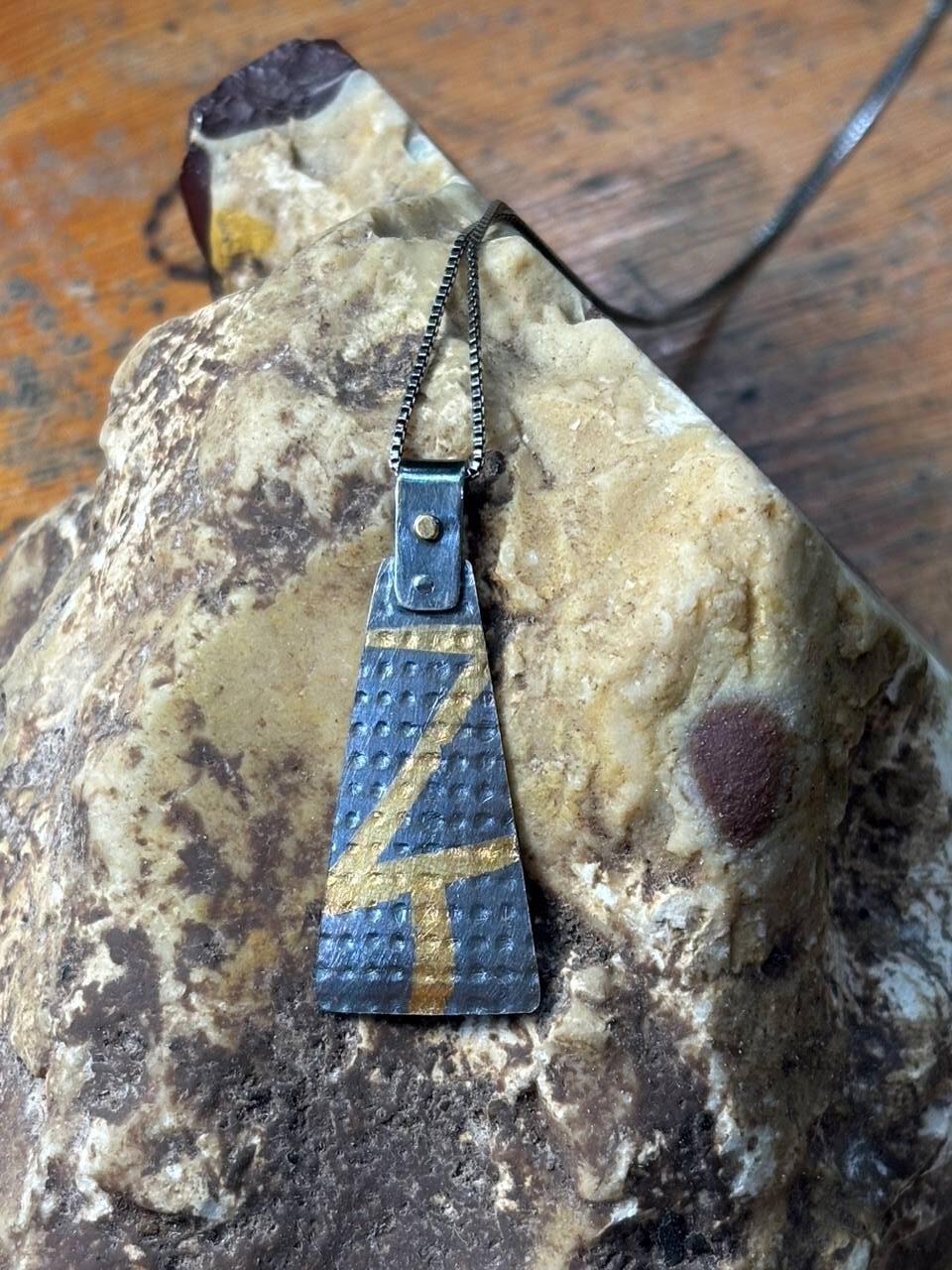 Student work: earrings in long triangle shape made fabricated out of silver argentium and gold leaf in keumboo technique