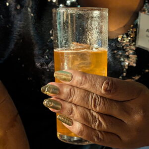 drink in hand with elegant badass nails made of brass during Holiday Nails class at the jeweler's saw jewelry studio