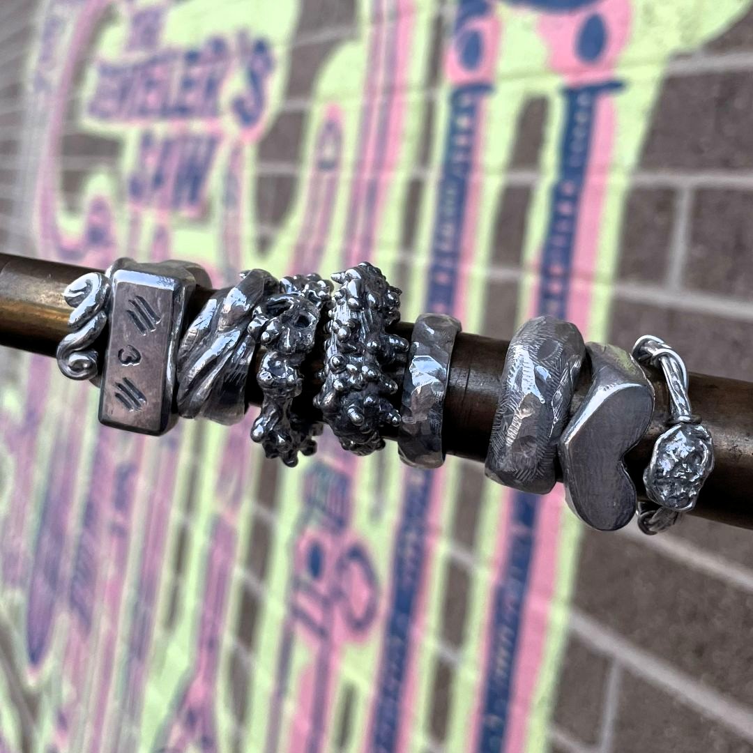 9 cast rings using lost wax casting, all student work displayed on a ring mandrel