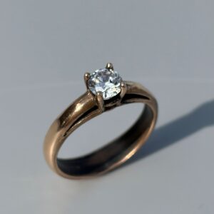 A solitaire engagement ring with a round gemstone in a four prong setting, handmade in a jewelry stone setting class at The Jeweler’s Saw in Austin.
