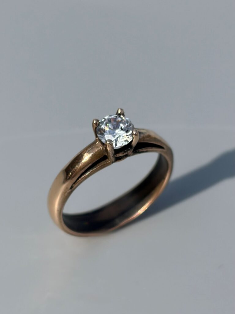 A solitaire engagement ring with a round gemstone in a four prong setting, handmade in a jewelry stone setting class at The Jeweler’s Saw in Austin.