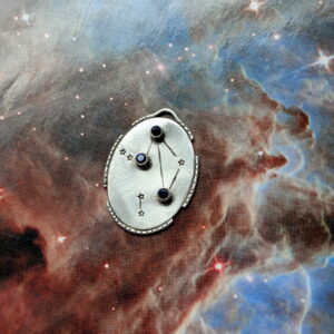 Sterling silver celestial pendant with blue gemstones and stamped constellation details, handmade at The Jeweler’s Saw jewelry studio in Austin.